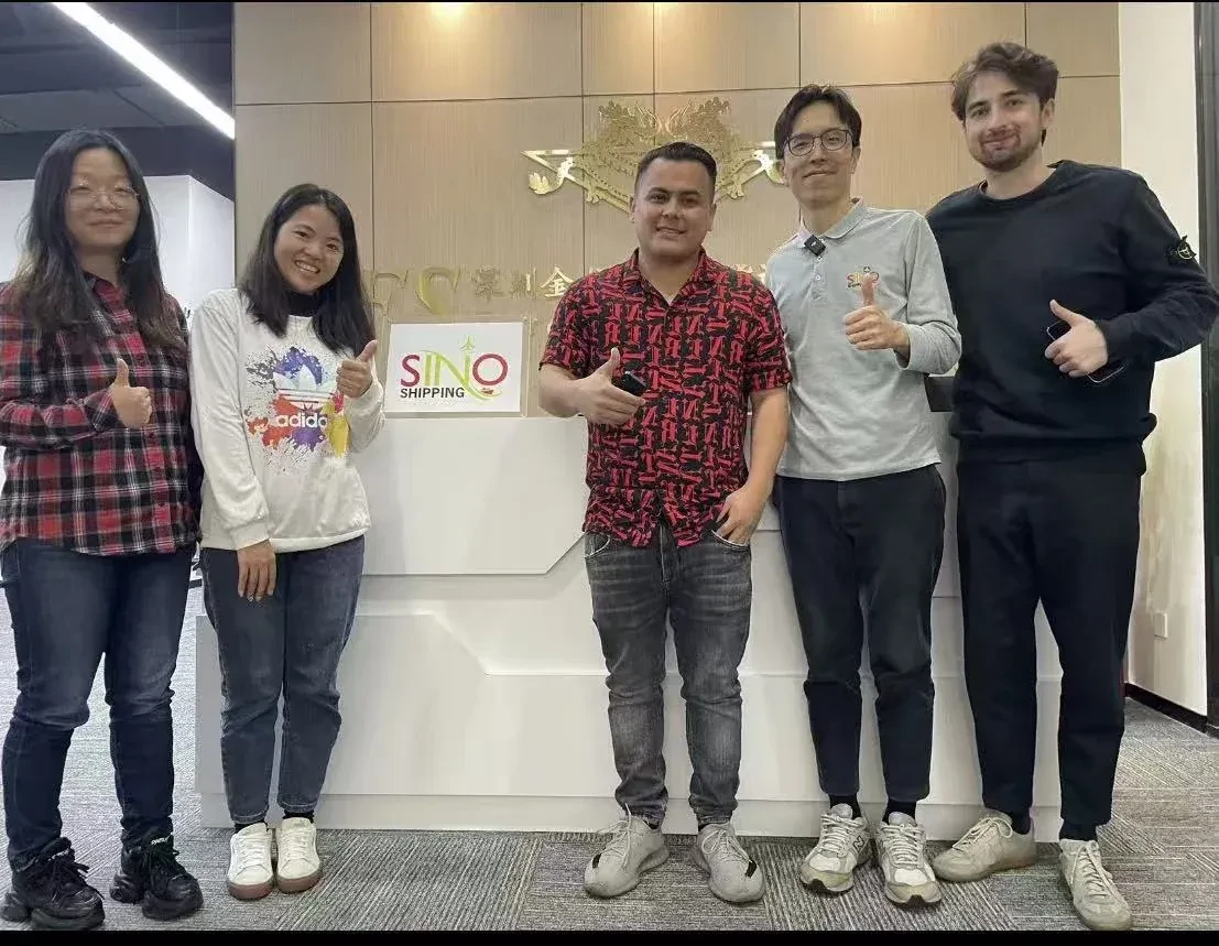 Nuestro equipo de Shenzhen recibe a tres clientes internacionales frente al logo SINO.