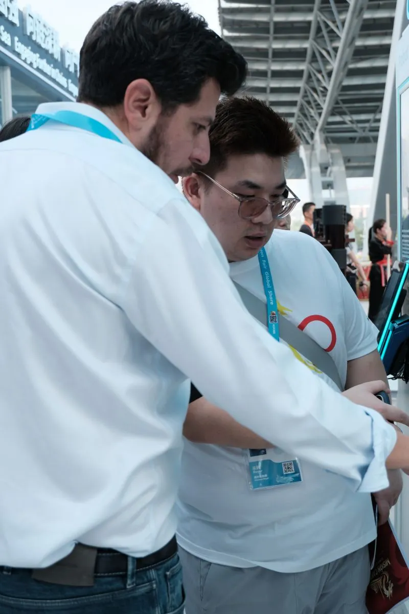 Membro da equipe da SINO Shipping ajudando um comprador em um ponto de registro da Canton Fair