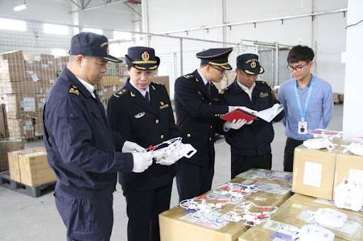 Oficiales de aduana inspeccionando mercancía importada en puerto chino