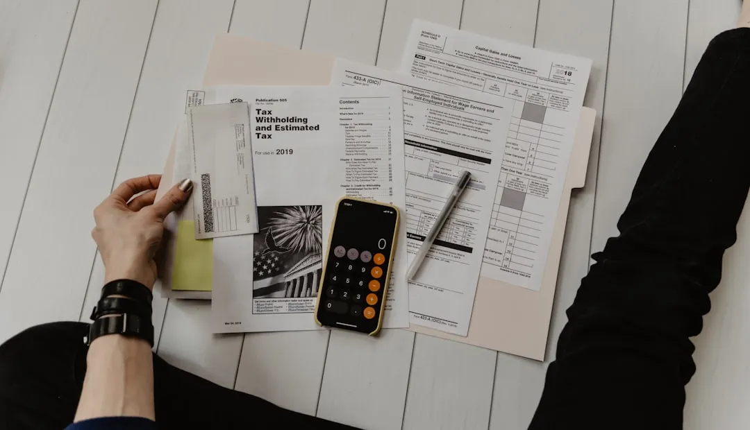 Persona calculando impuestos con papel y calculadora