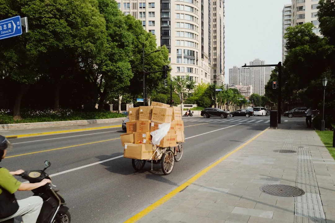 Mensajero transportando en bicicleta una alta pila de cajas