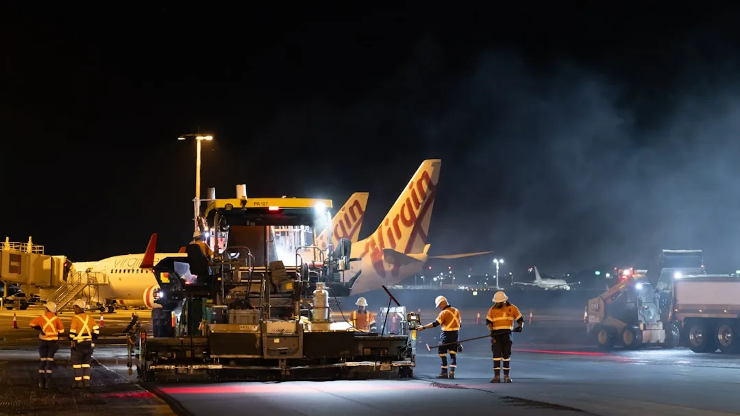 Personal de pista cargando un avión de noche en el aeropuerto