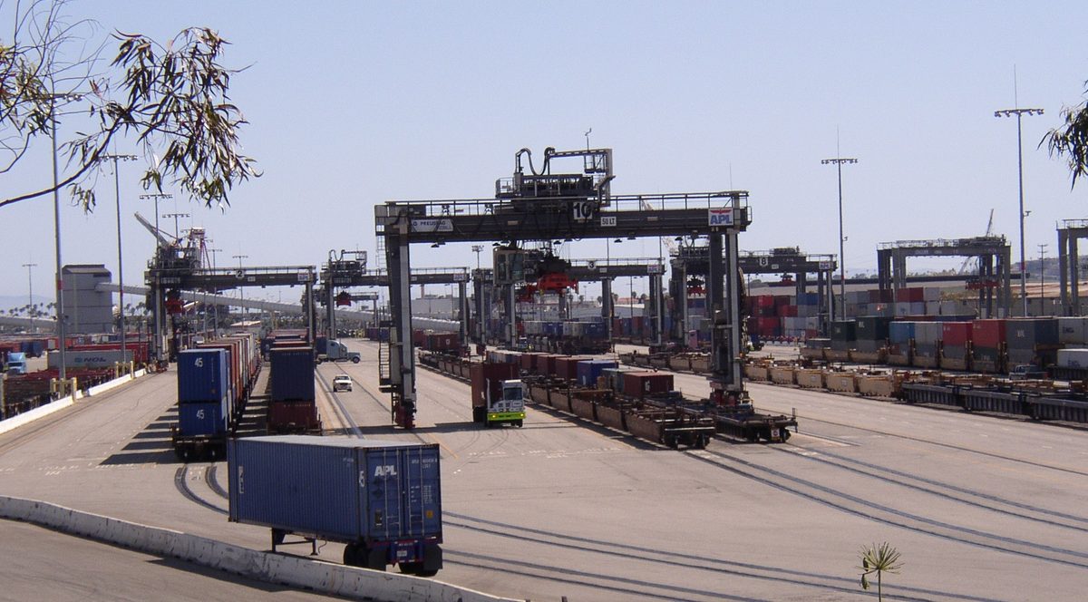 Transferência de contêiner do navio para o trem no terminal portuário intermodal