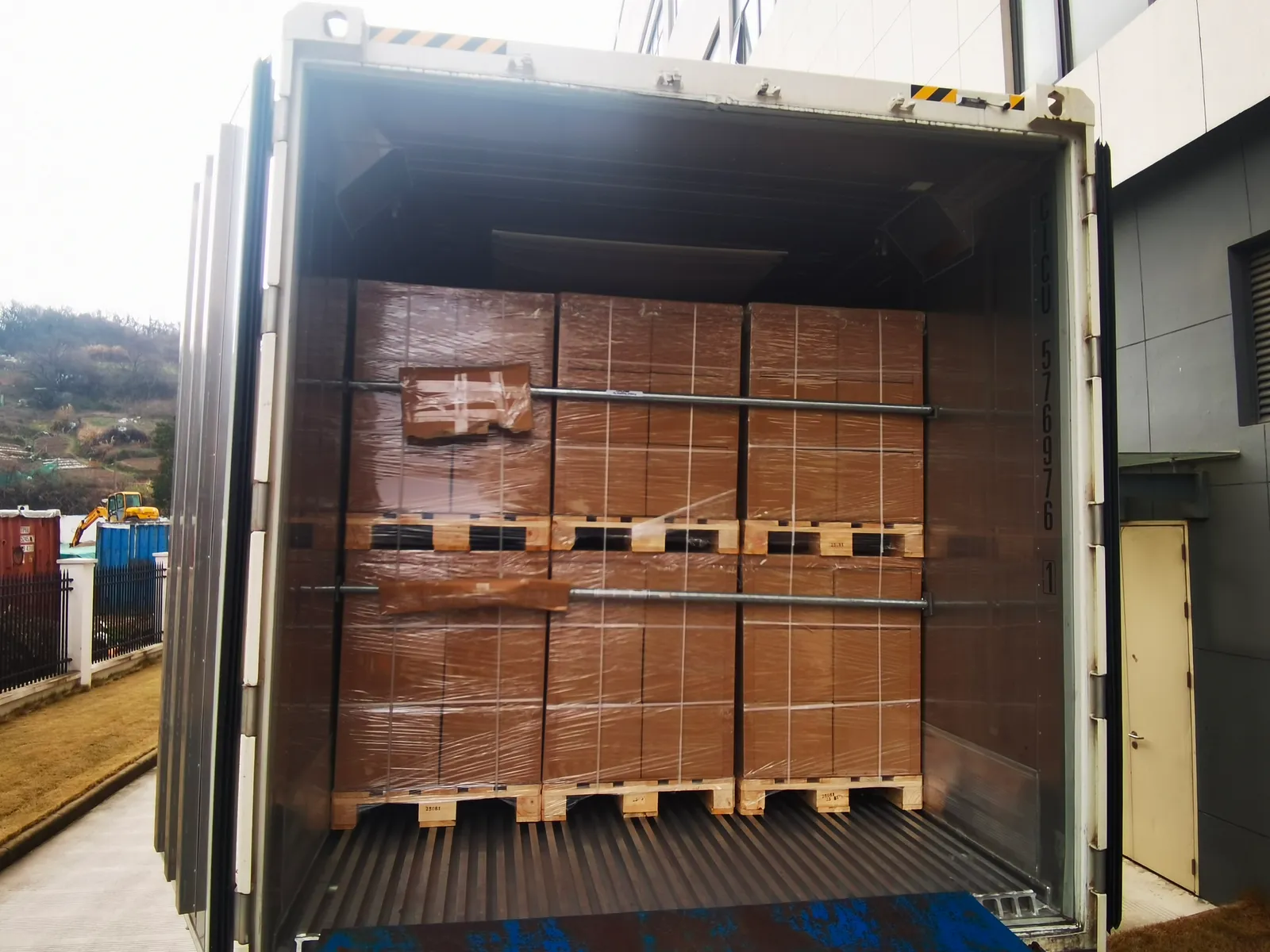Contenedor FCL cargado con palets y asegurado con barras de carga por el equipo de SINO Shipping