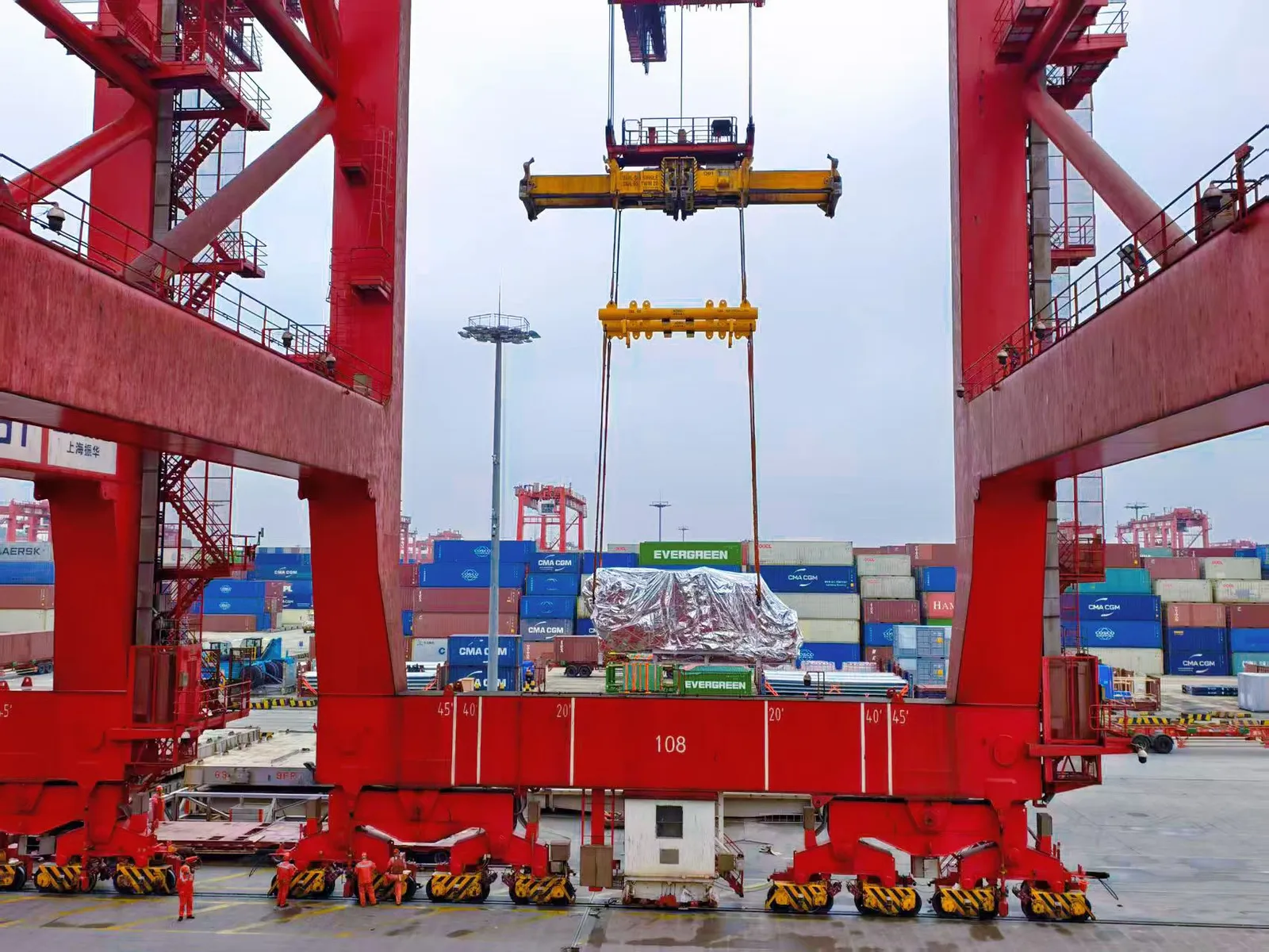 Grúa pórtico cargando un flat rack en un terminal de contenedores chino, operación gestionada por SINO Shipping