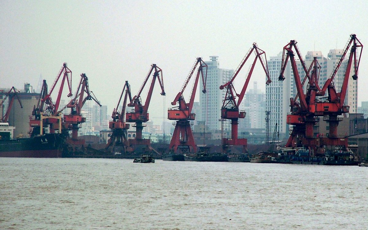 Terminal de contenedores en el puerto de Shanghai con contenedores apilados y grúas pórtico
