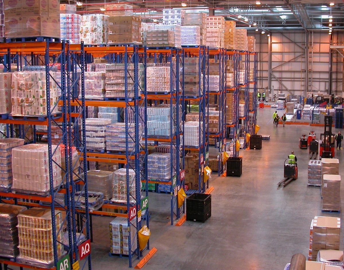 Interior de centro de distribución con pasillos de almacenamiento y operaciones logísticas